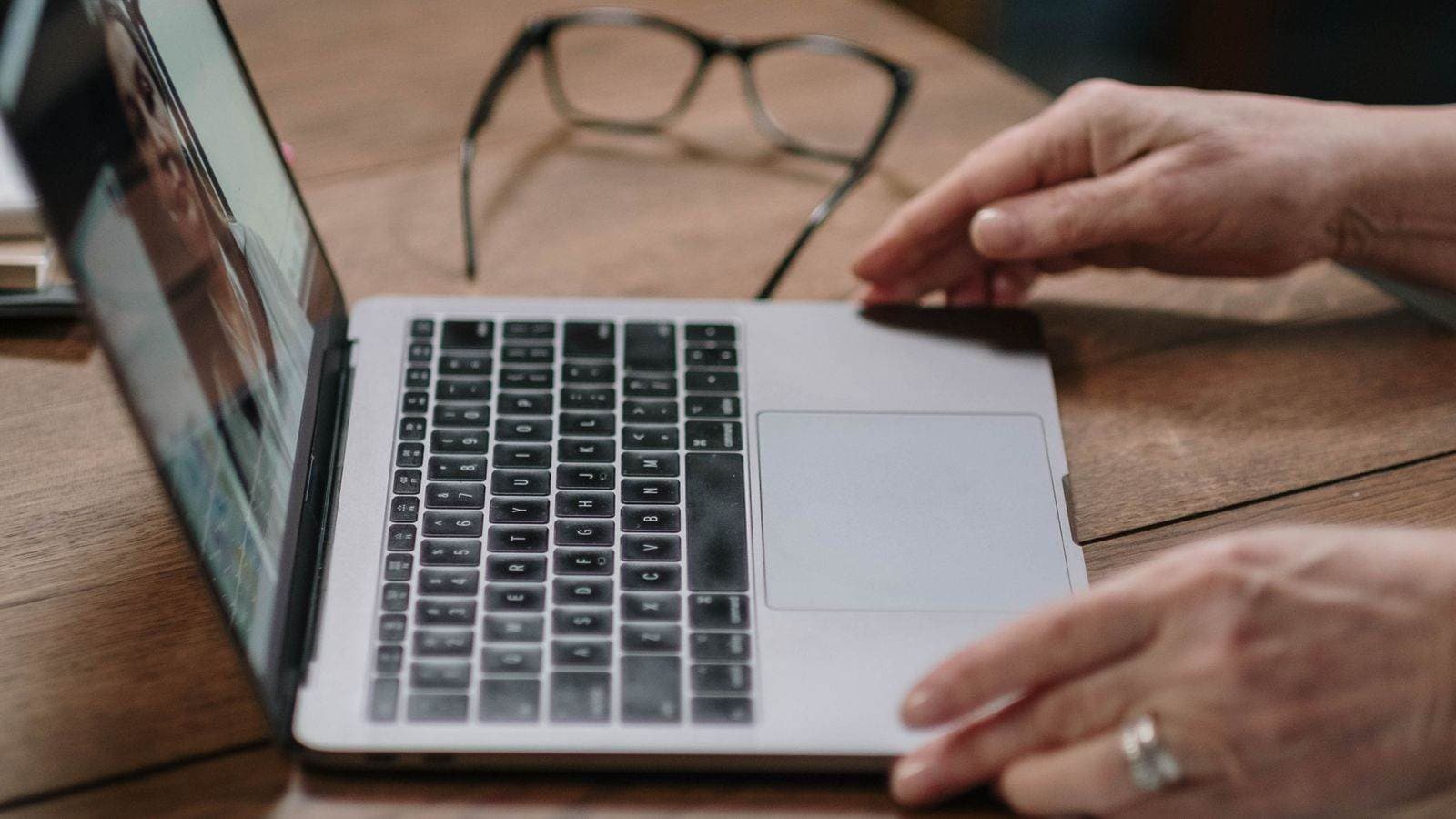Laptop z włączoną kamerą i dokumentami na biurku — od 13 marca 2026 r. rozprawy przed KIO mogą odbywać się zdalnie
